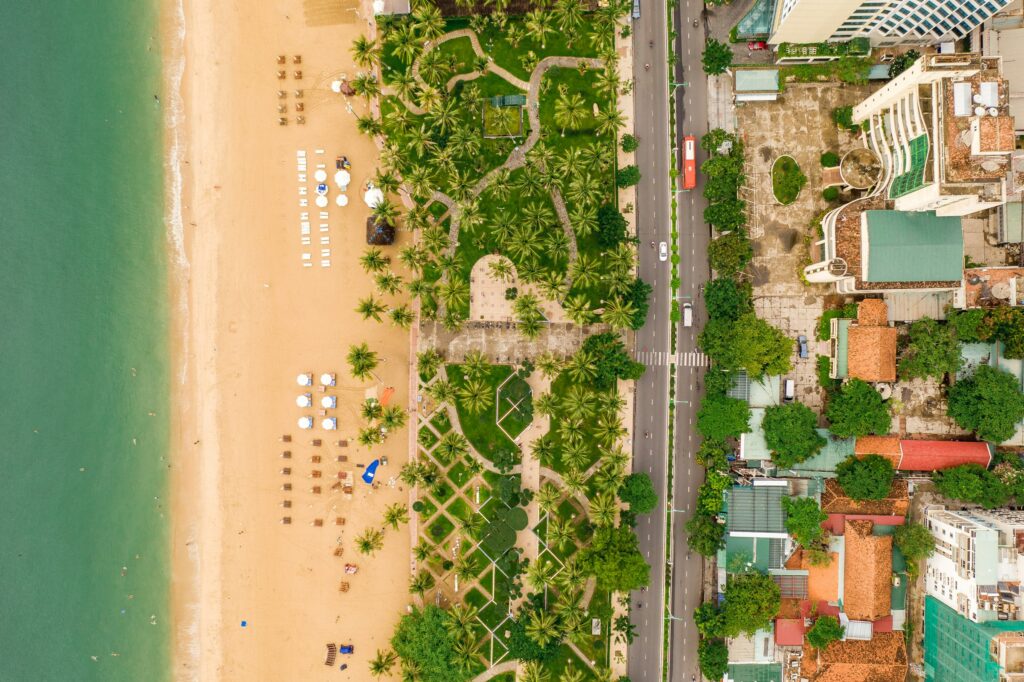 Strand und Uferpark von Nha Trang in Vietnam von oben, daneben die Küstenstraße